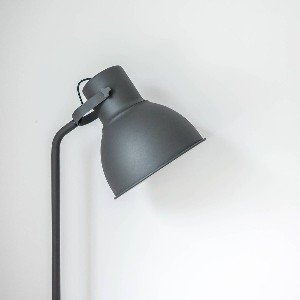 Black modern floor lamp against white background.