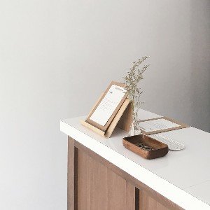 Minimalist desk with vase and clipboard.