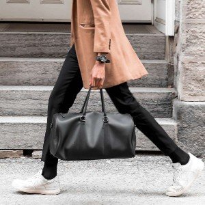 Person walking with a stylish black bag.