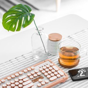 Vintage keyboard and tea on minimalist desk setup.